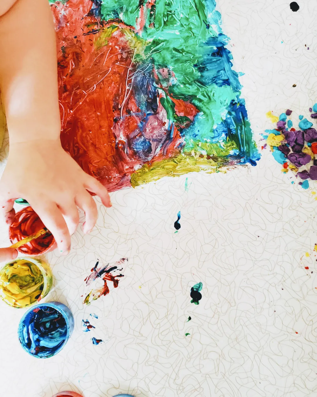 Taller de pintura de dits a Espai Tribu (Vilanova i la Geltrú): mans i peus d'un infant explorant colors sobre paper.